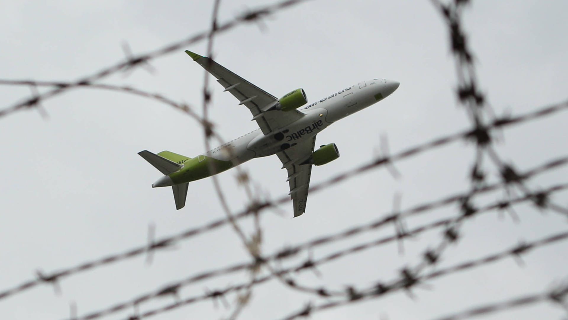 Eine Maschine der Air Baltic fliegt über einen Gitterzaun am Flughafen Hamburg (Symbolbild): Die Innenbehörde hat die Abschiebung von Straftätern intensiviert.