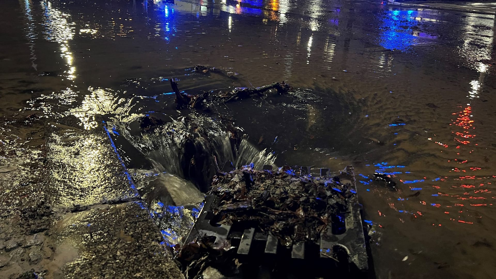 Wasser fließt auf der Seestraße am Silvesterabend in einen Gulli. Am Abend war dort eine große Wasserleitung geplatzt.