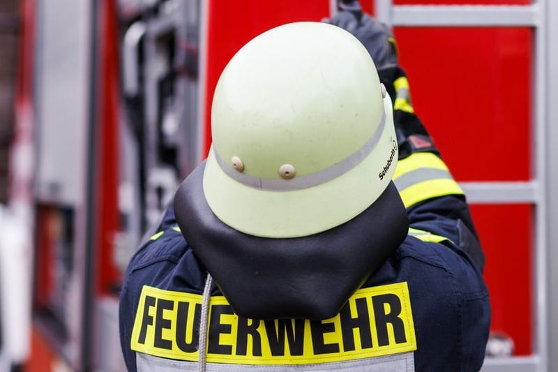 Ein Feuerwehrmann holt eine Leiter vom Dach eines Einsatzfahrzeugs (Symbolbild): 40 Einsatzkräfte rückten am Freitag in Hürth aus.