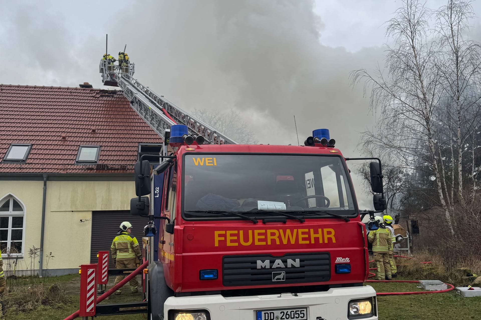 Die Feuerwehr löscht mit einer Drehleiter: Der Einsatz wird voraussichtlich noch bis in den Nachmittag andauern.