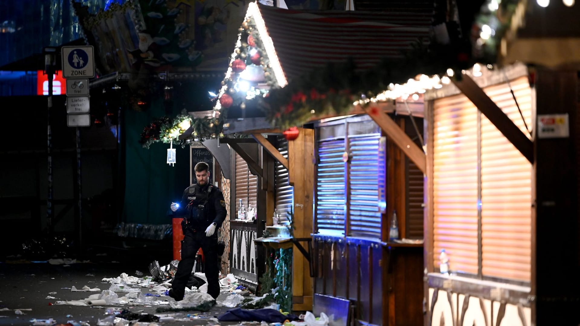 Magdeburg: Ein Polizist untersucht den Tatort auf dem Weihnachtsmarkt.