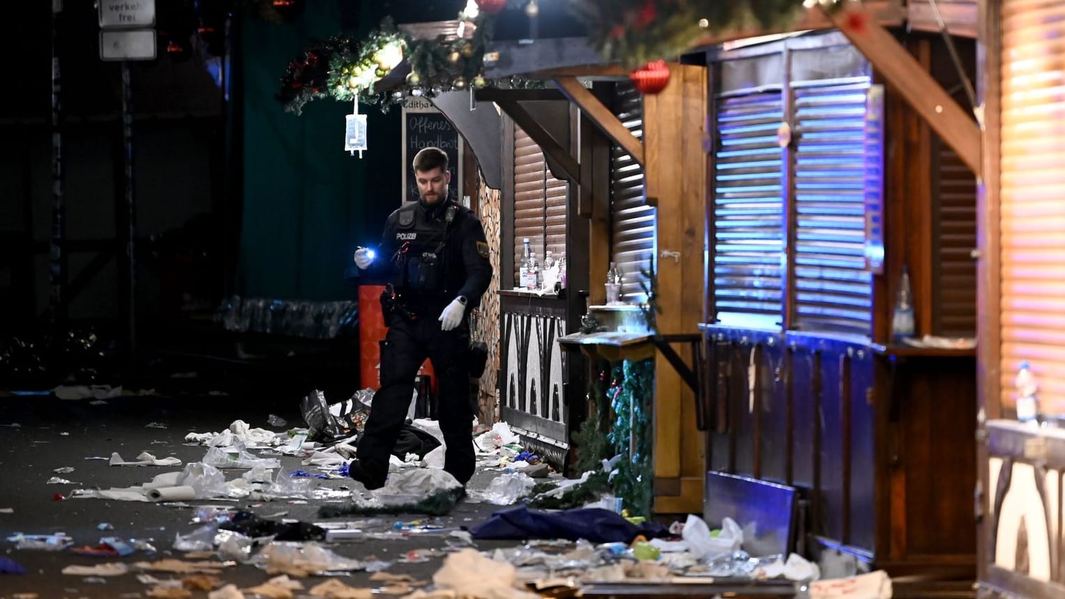 Magdeburg: Ein Polizist untersucht den Tatort auf dem Weihnachtsmarkt.