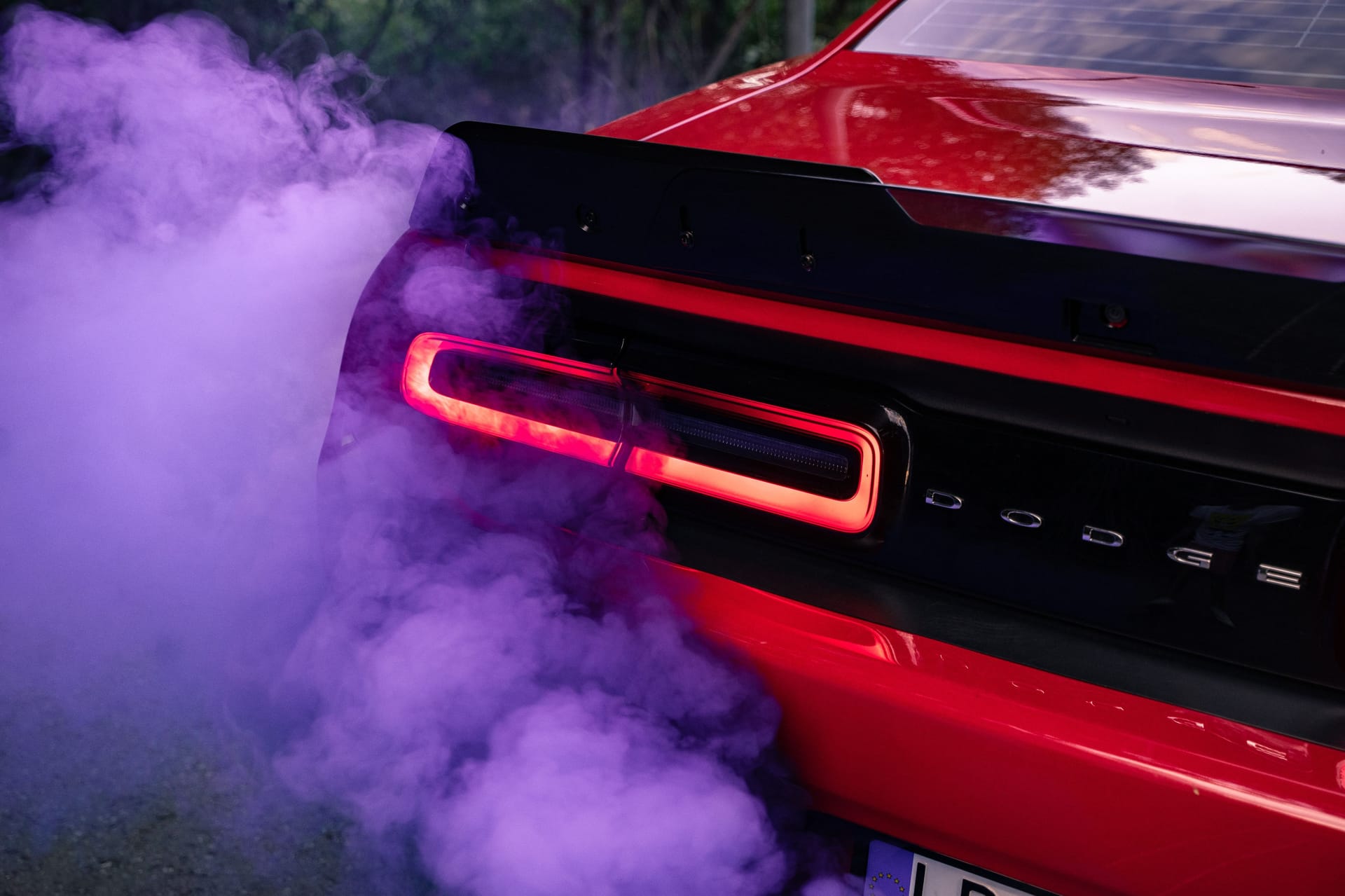 Dodge Challenger sports muscle car red with racing smoke red purple