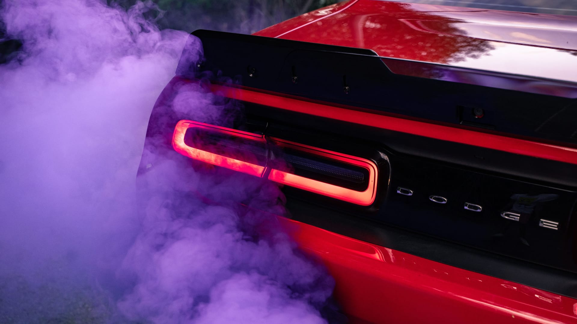 Dodge Challenger sports muscle car red with racing smoke red purple