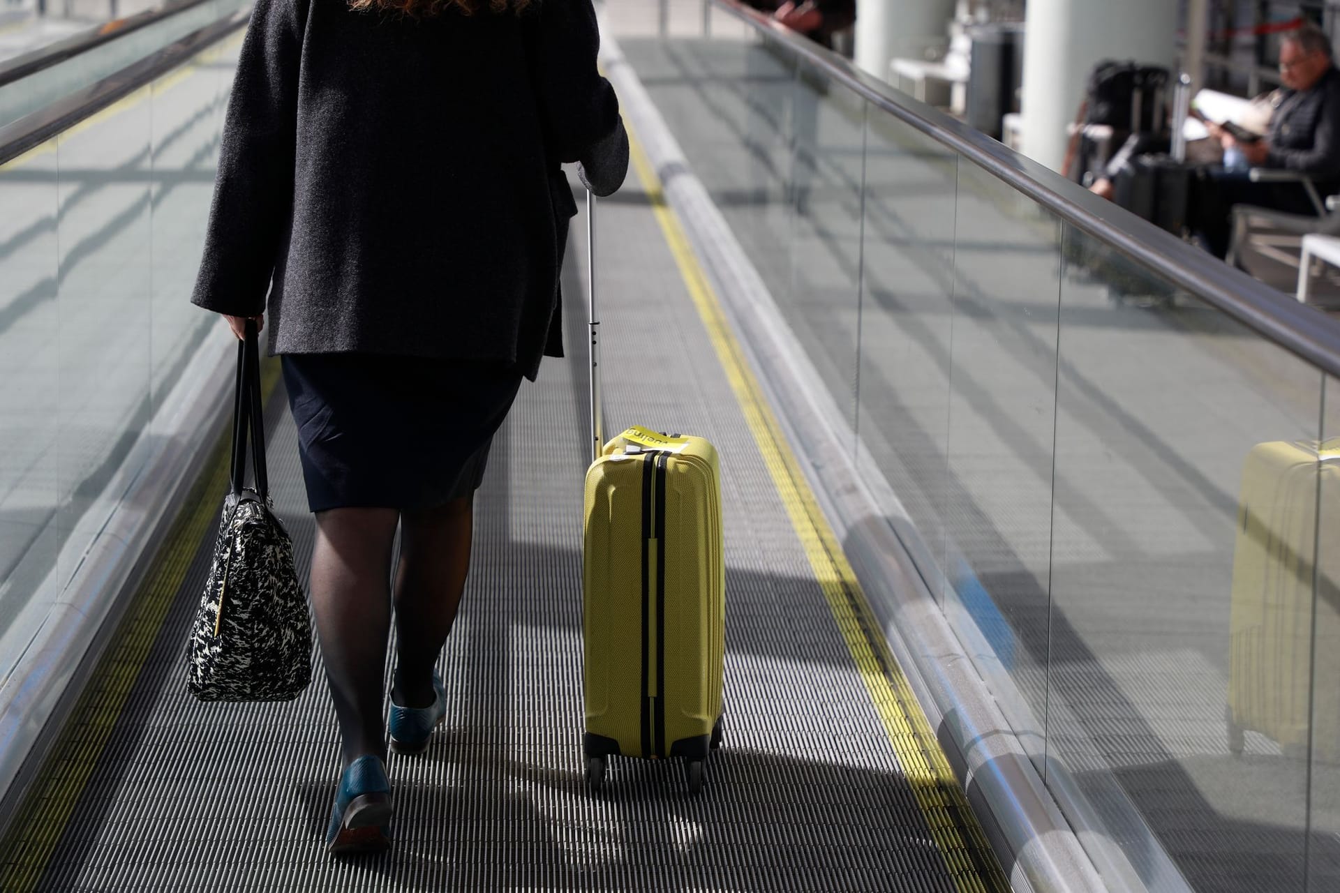 Eine Frau mit Rollkoffer am Flughafen