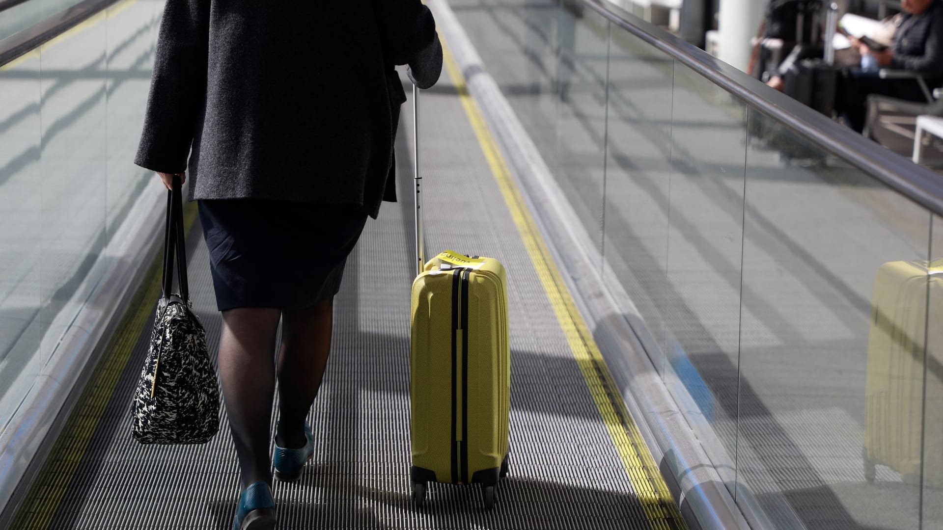 Eine Frau mit Rollkoffer am Flughafen