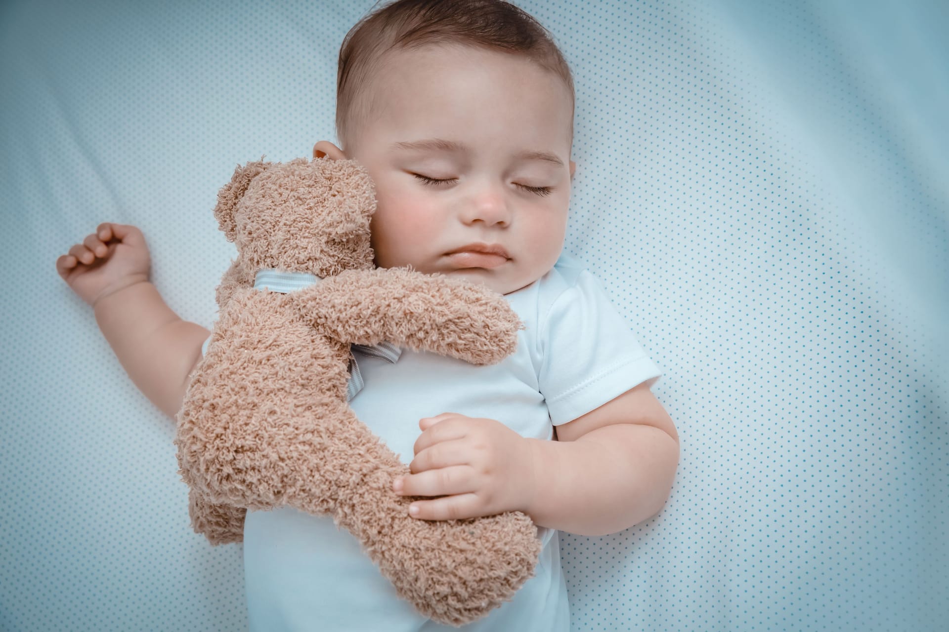 Sweet baby napping with a toy bear