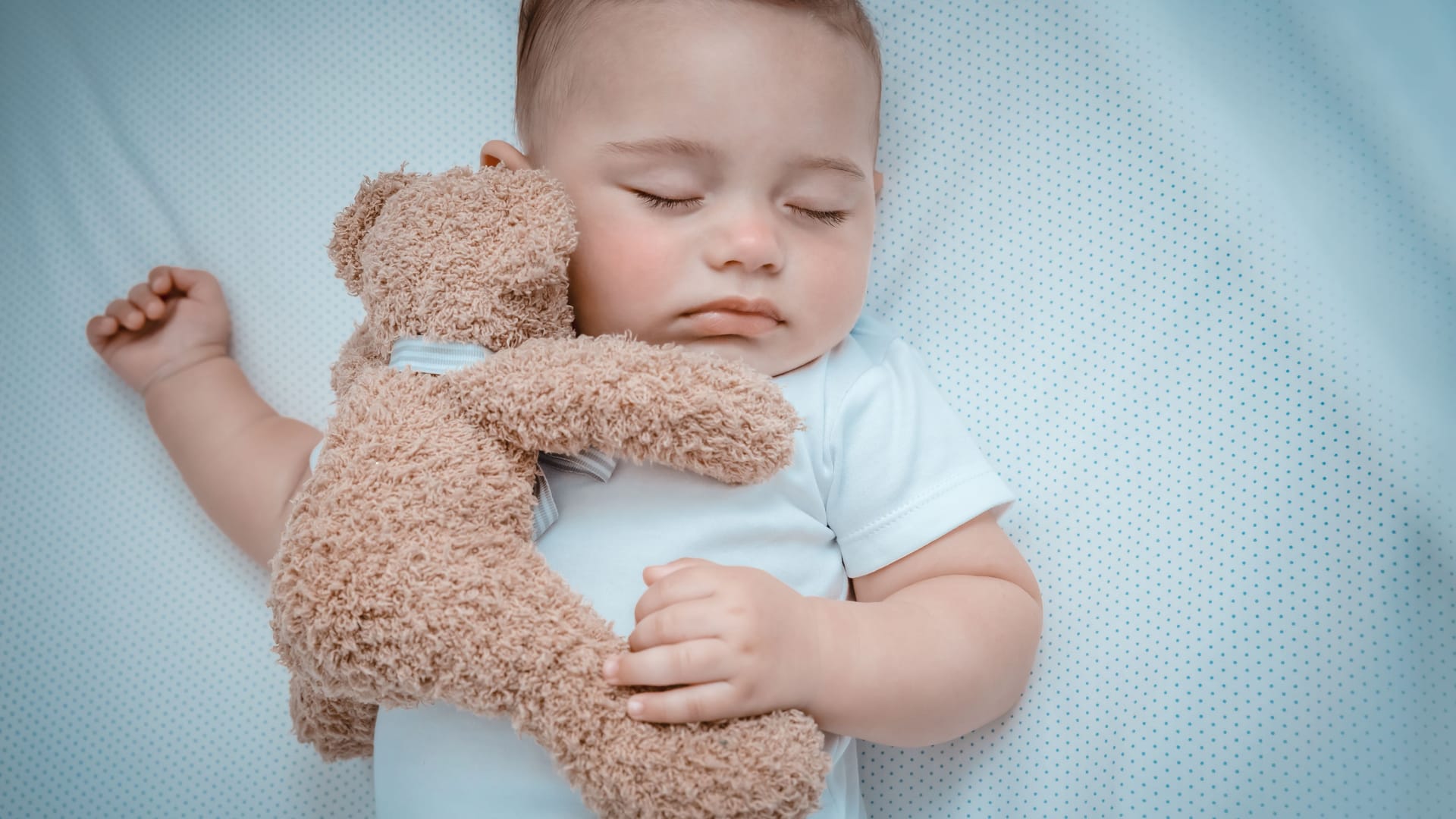 Sweet baby napping with a toy bear