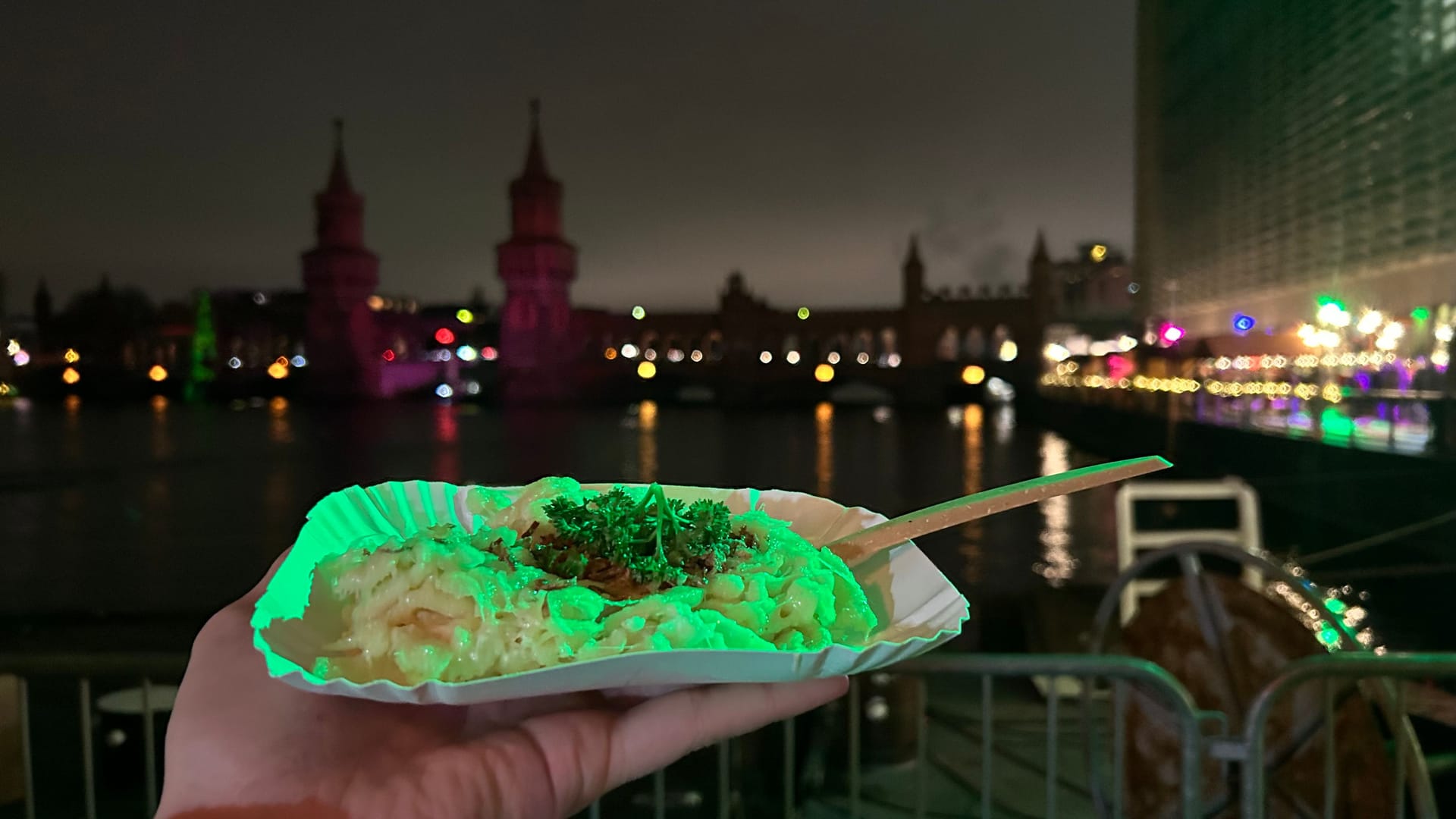 Eine Portion Käsespätzle: Der Weihnachtsmarkt liegt direkt an der Spree, im Hintergrund ist die Oberbaumbrücke zu sehen.