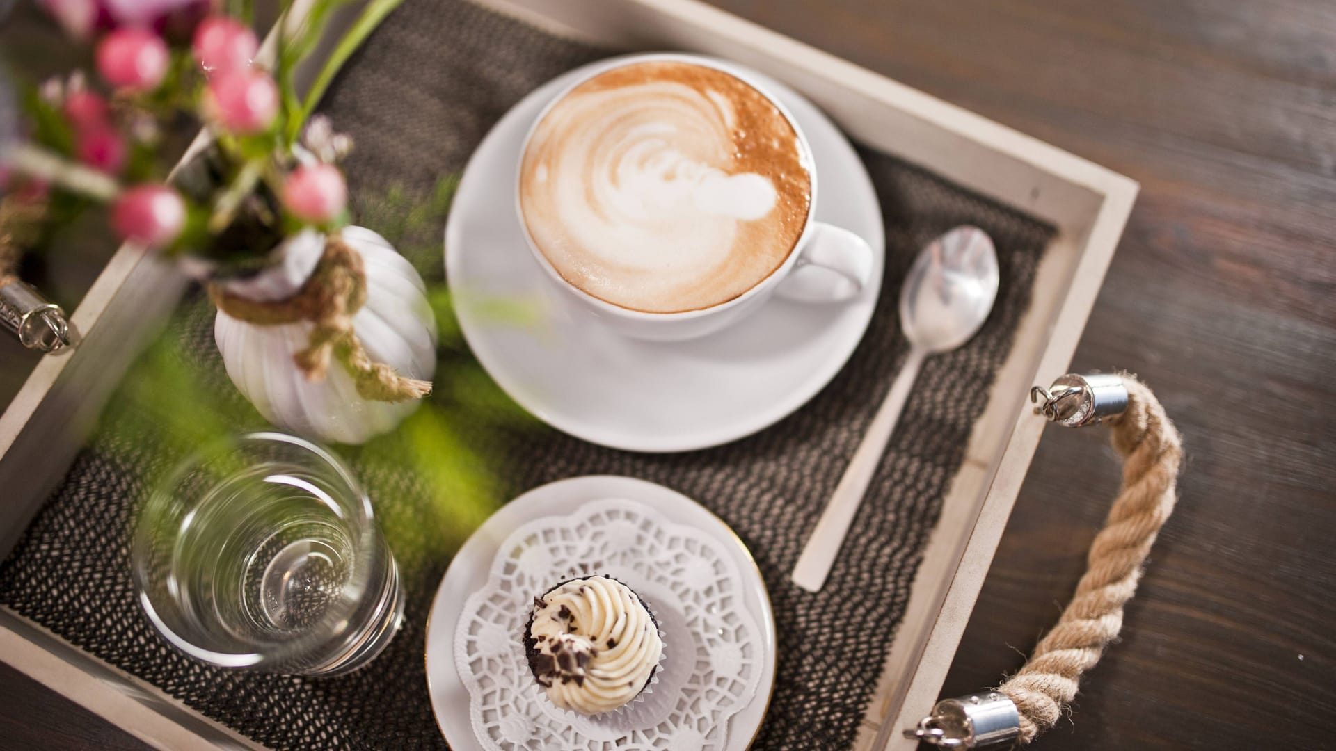 Ein Tablett mit einer Tasse Cappuccino neben einem Cupcake: In Hannover gibt es einige Cafés, die ein Magazin als beste Deutschlands gekürt hat.