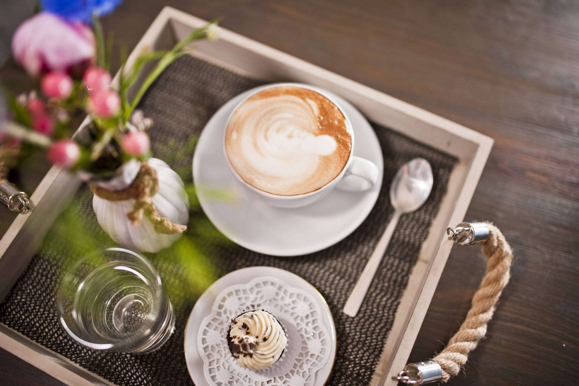 Ein Tablett mit einer Tasse Cappuccino neben einem Cupcake: In Hannover gibt es einige Cafés, die ein Magazin als beste Deutschlands gekürt hat.