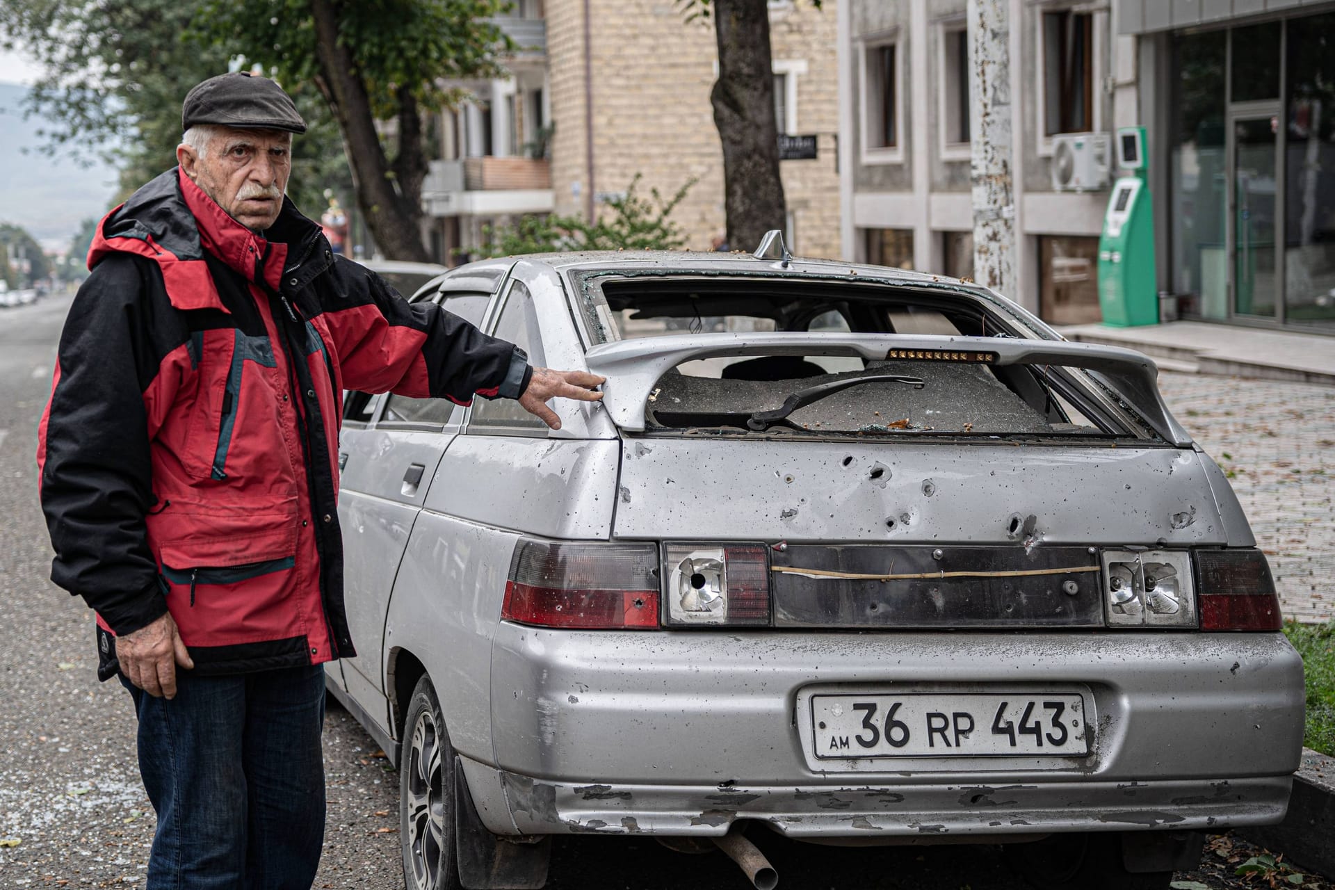 Ein Armenier zeigt in Bergkarabach auf ein zerstörtes Auto (Archivbild): Der Frieden im Kaukasus ist brüchig.