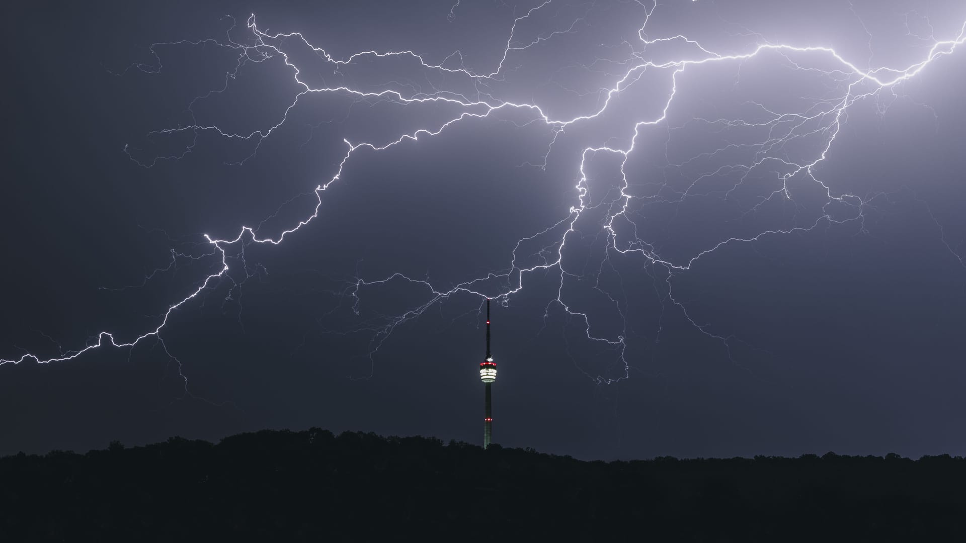 Der Fernsehturm im Gewitter: Das Wetter an Silvester in Berlin und Brandenburg droht ungemütlich zu werden. Partys unter freiem Himmel könnten ins Wasser fallen.