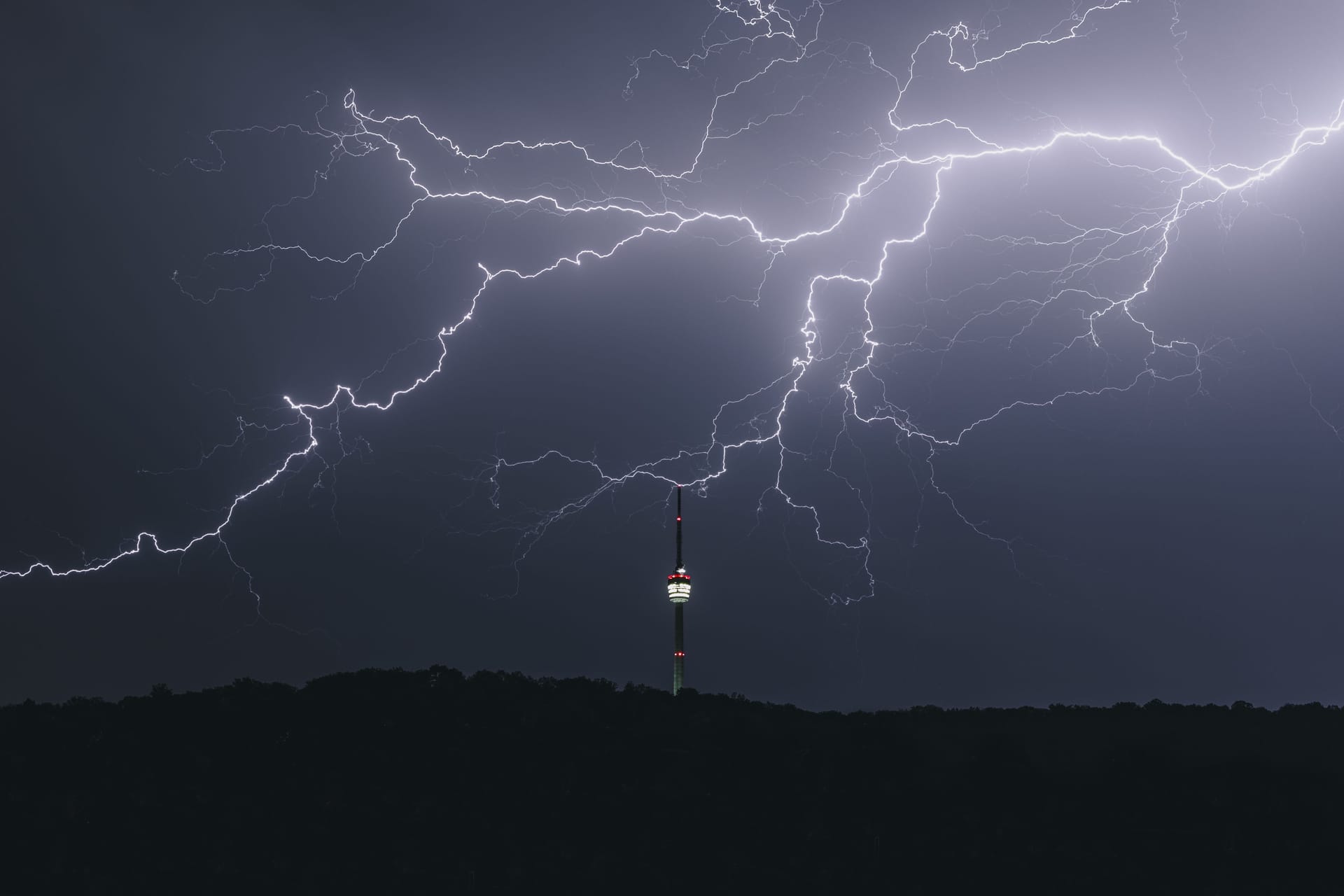 Der Fernsehturm im Gewitter: Das Wetter an Silvester in Berlin und Brandenburg droht ungemütlich zu werden. Partys unter freiem Himmel könnten ins Wasser fallen.