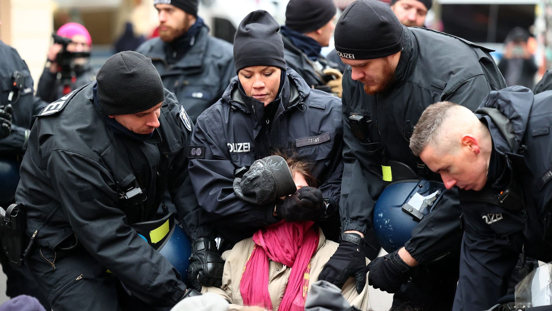 Die Polizei entfernt Menschen, die während einer Gegendemonstration gegen eine rechte Demonstration in Berlin die Straße blockieren.