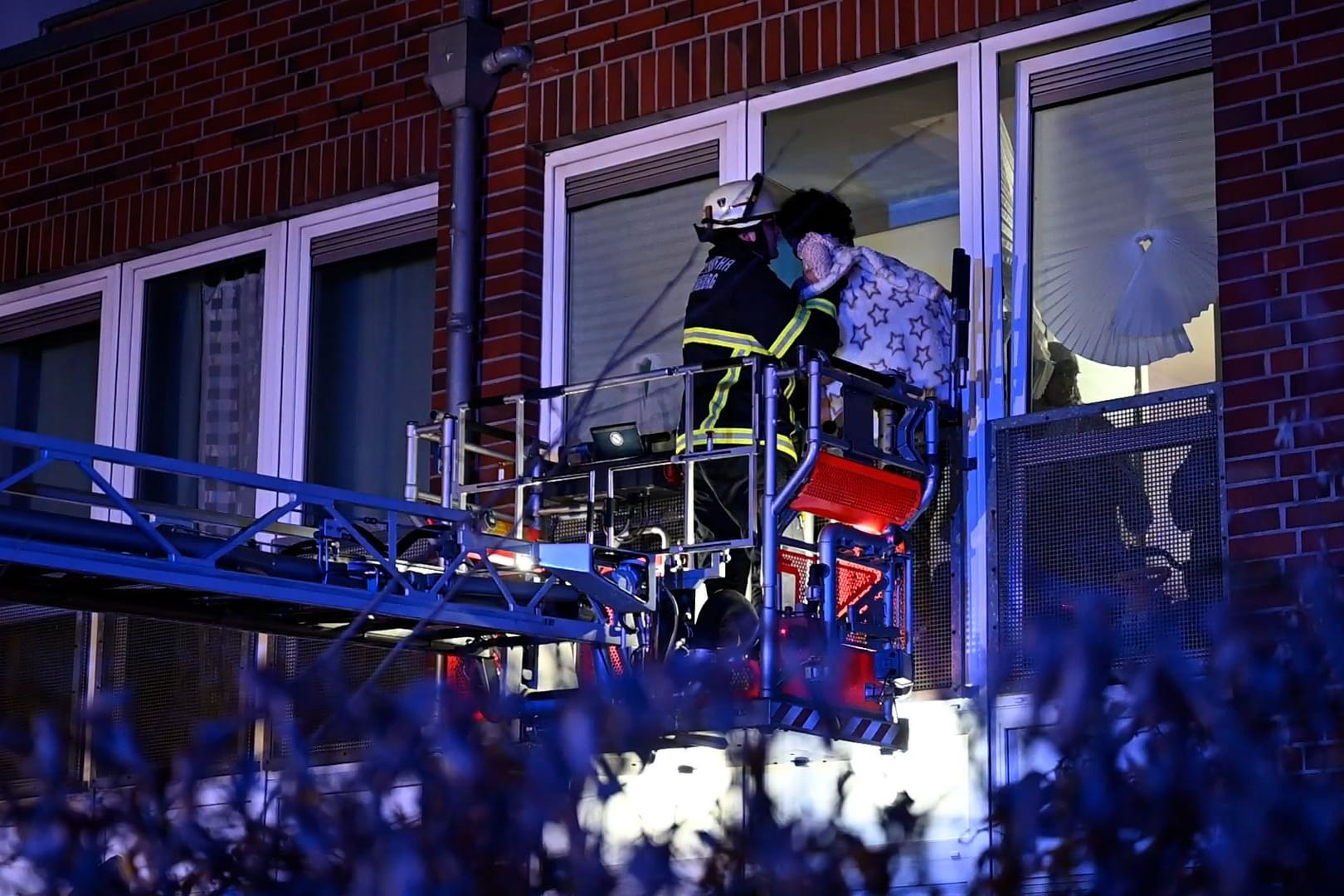 Feuerwehrleute retten Bewohner über Drehleiter: Mehrere Menschen konnten das Haus nicht selbstständig verlassen.