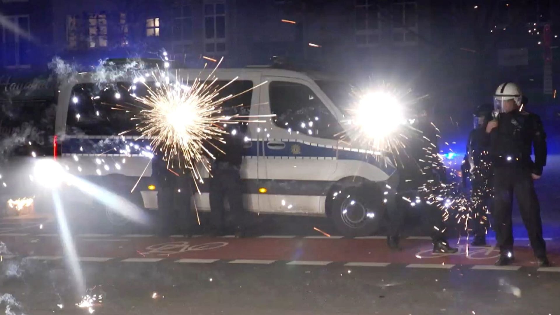 Einsatzkräfte in der Silvesternacht hinter explodierendem Feuerwerk (Archivbild): In der Nacht zu 2025 sind 3.000 Polizisten im Einsatz.