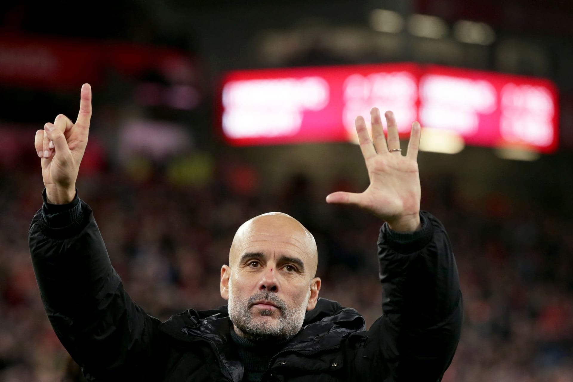 Pep Guardiola zeigt die Zahl sechs: Er reagiert auf spöttische Gesänge der Liverpool-Fans.