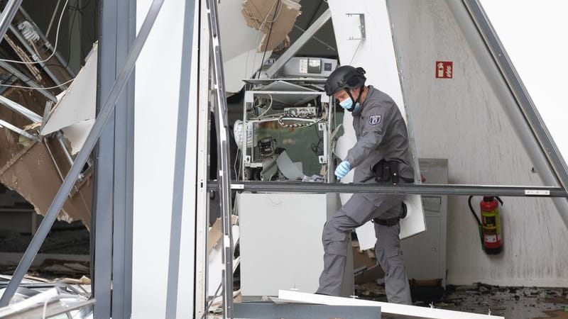 Ein Polizist vom Kampfmittelräumdienst steht in einer Bankfiliale in Berlin, in der ein Geldautomat gesprengt wurde (Archivbild): Durch die Explosion wurde die Bankfiliale erheblich beschädigt.