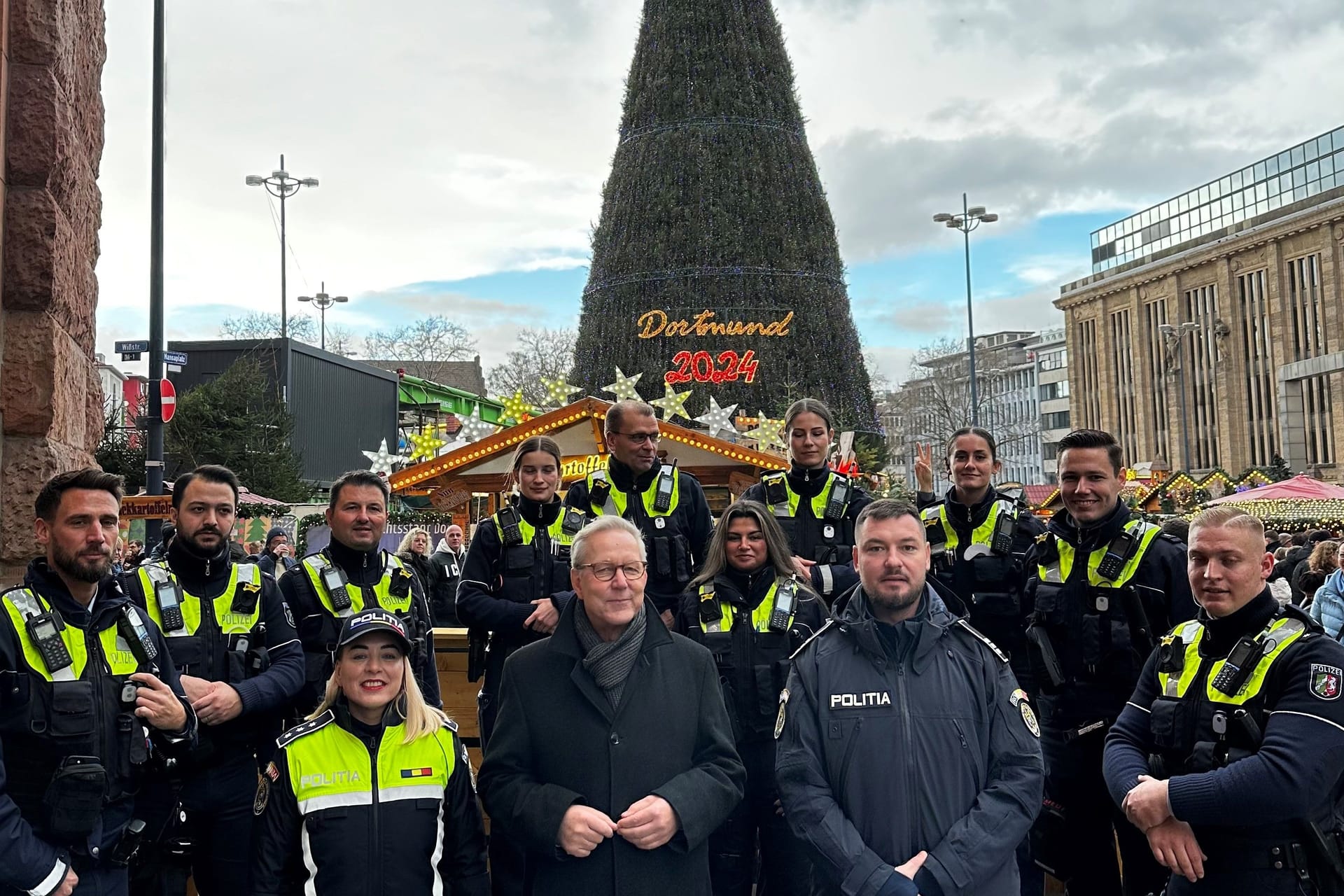 Polizeipräsident Gregor Lange (vorn, Mitte) und ein Team der Polizeiinspektion 1 begrüßten Polizeikommissarin Lorena Marin und Polizeihauptmeister Sorin Giurgiuca auf dem Weihnachtsmarkt in Dortmund.