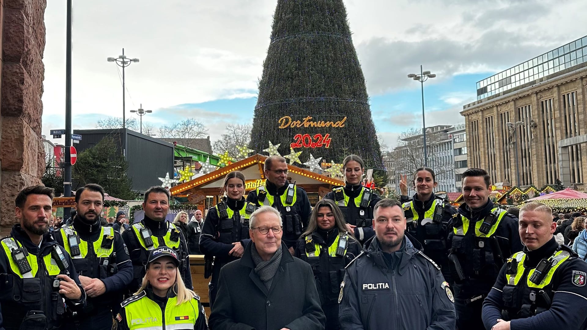 Polizeipräsident Gregor Lange (vorn, Mitte) und ein Team der Polizeiinspektion 1 begrüßten Polizeikommissarin Lorena Marin und Polizeihauptmeister Sorin Giurgiuca auf dem Weihnachtsmarkt in Dortmund.