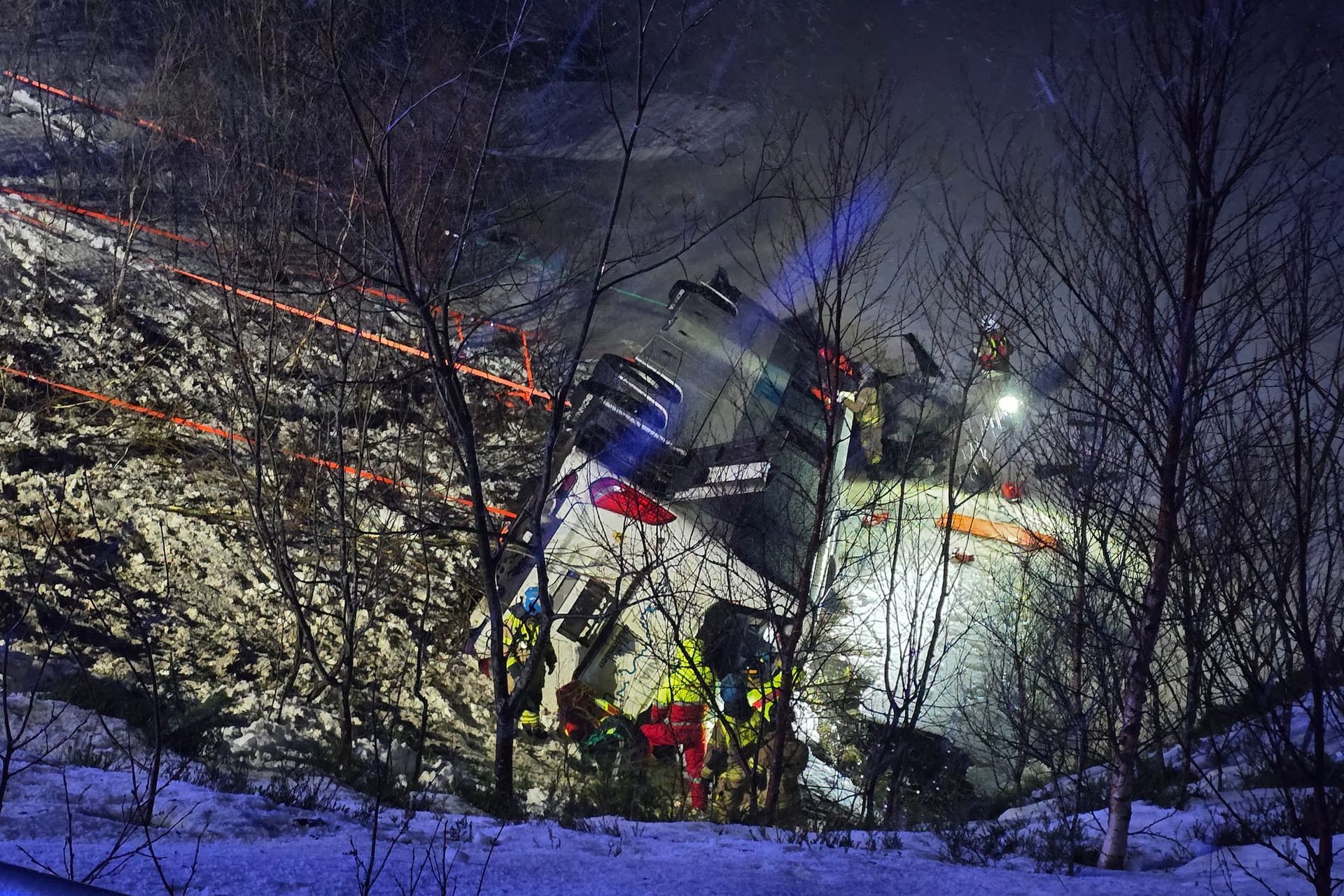 Rettungskräfte arbeiten am Ort des Unfalls. Bei einem Busunglück in Norwegen sind drei Menschen ums Leben gekommen und mehrere Personen schwer verletzt worden. Das Fahrzeug sei von einer Straße abgekommen und teilweise in einen See geraten, teilte die Polizei mit. An Bord waren mehrere ausländische Staatsbürger.