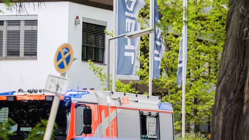 Flaggen der Firma Diehl sind in Berlin-Lichterfelde bei einem Brand zu sehen. In einem Betrieb in Berlin-Lichterfelde hat es Anfang Mai gebrannt. Die Staatsanwaltschaft geht von einer elektrotechnischen Ursache aus.