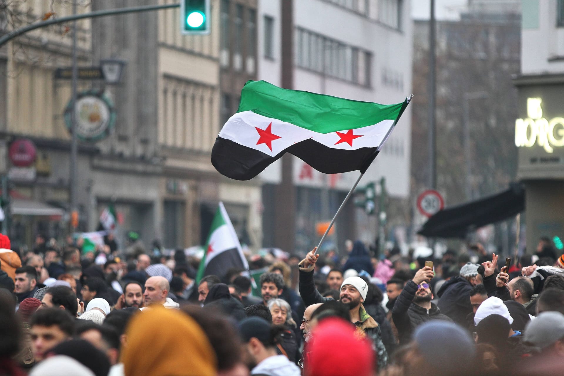 Syrer in Berlin feiern den Sturz von Assad in Syrien: Ein Mann mit syrischer Flagge wude angegriffen.