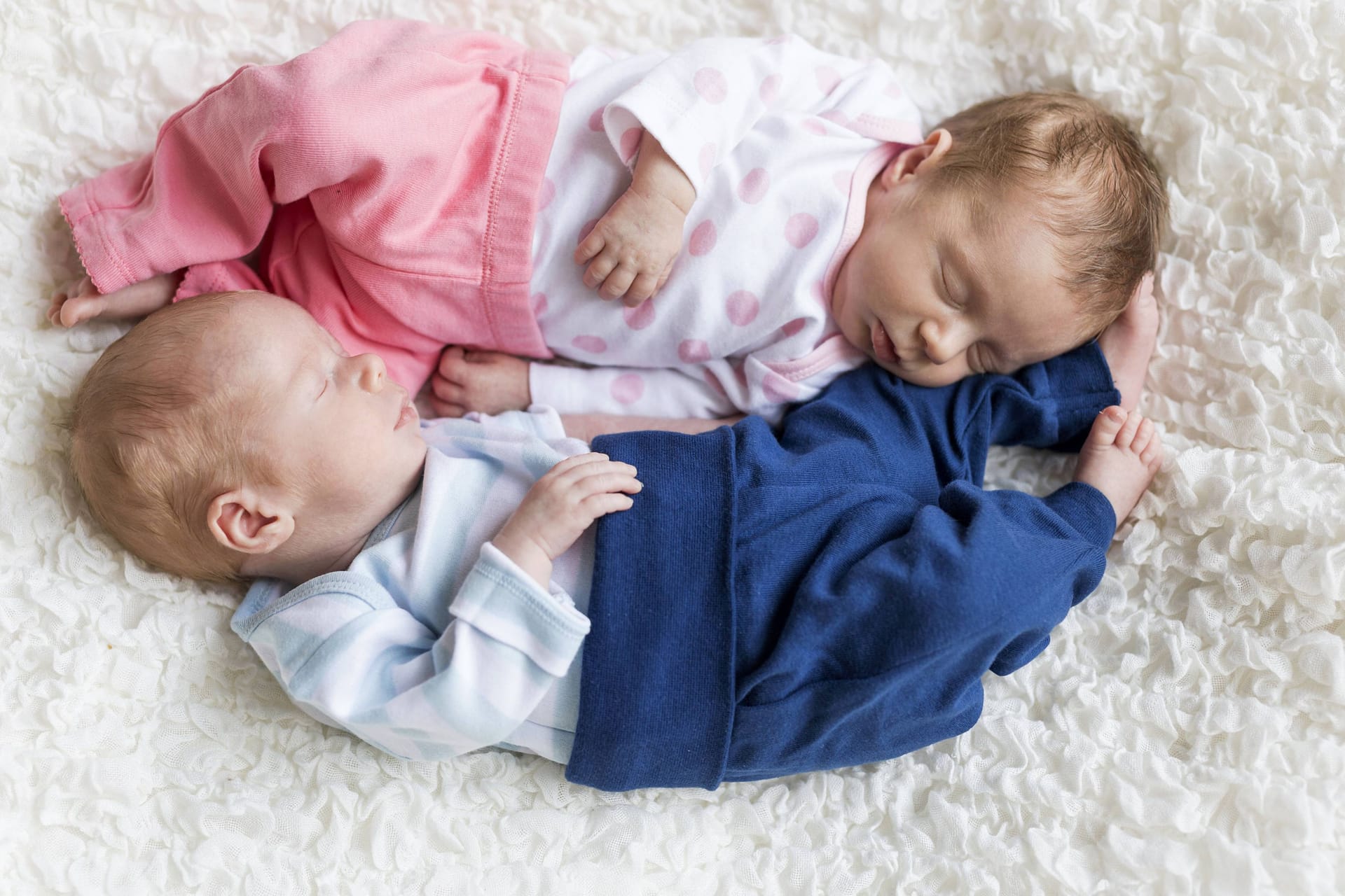 Zwei Neugeborene schlafen auf einem Teppich (Symbolbild): In Sachsen wählen Eltern besonders gern seltene Vornamen für ihre Babys.