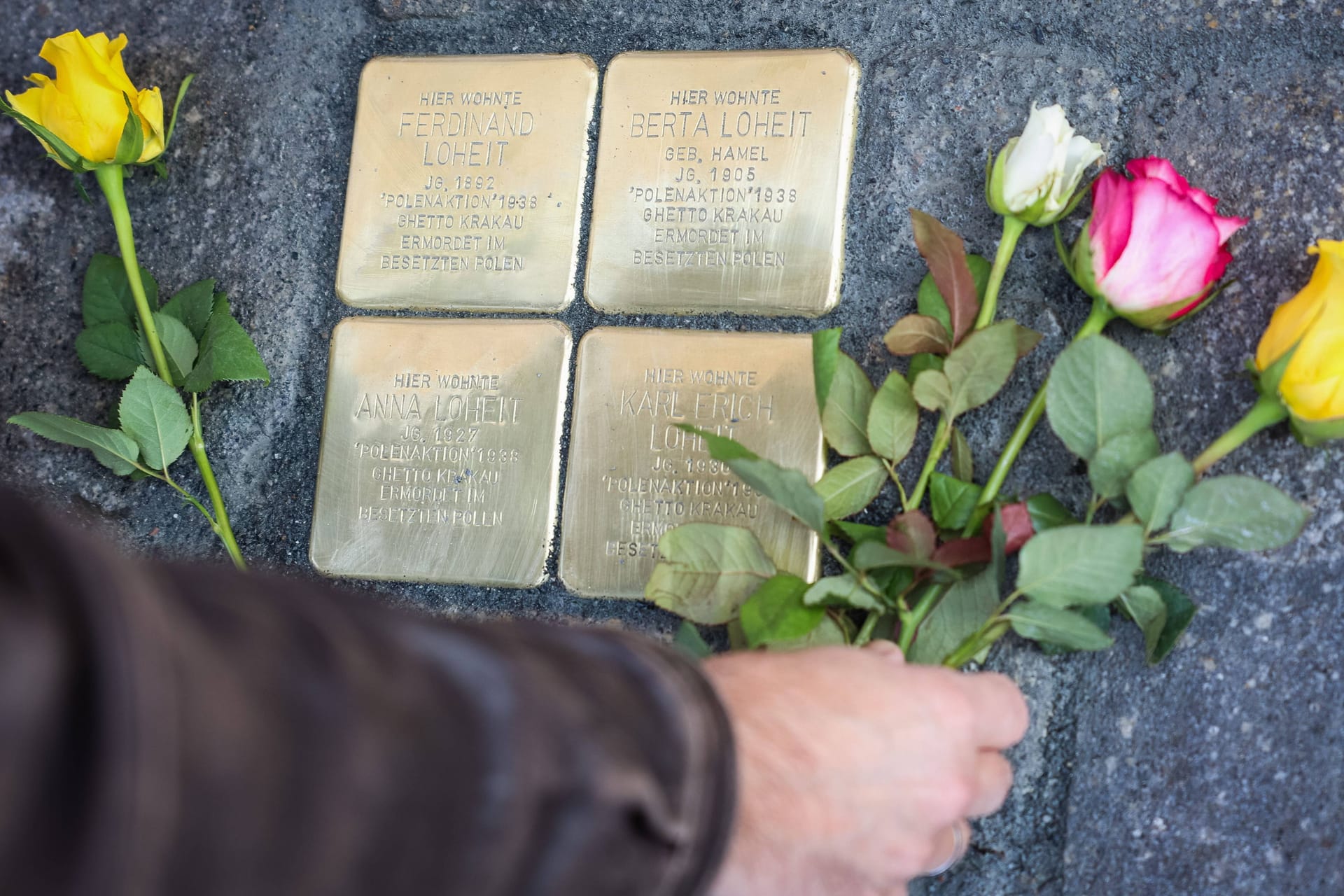 Rosen werden an den Stolpersteinen auf der Uhlandstraße 39 für Familie Loheit abgelegt (Archivbild):