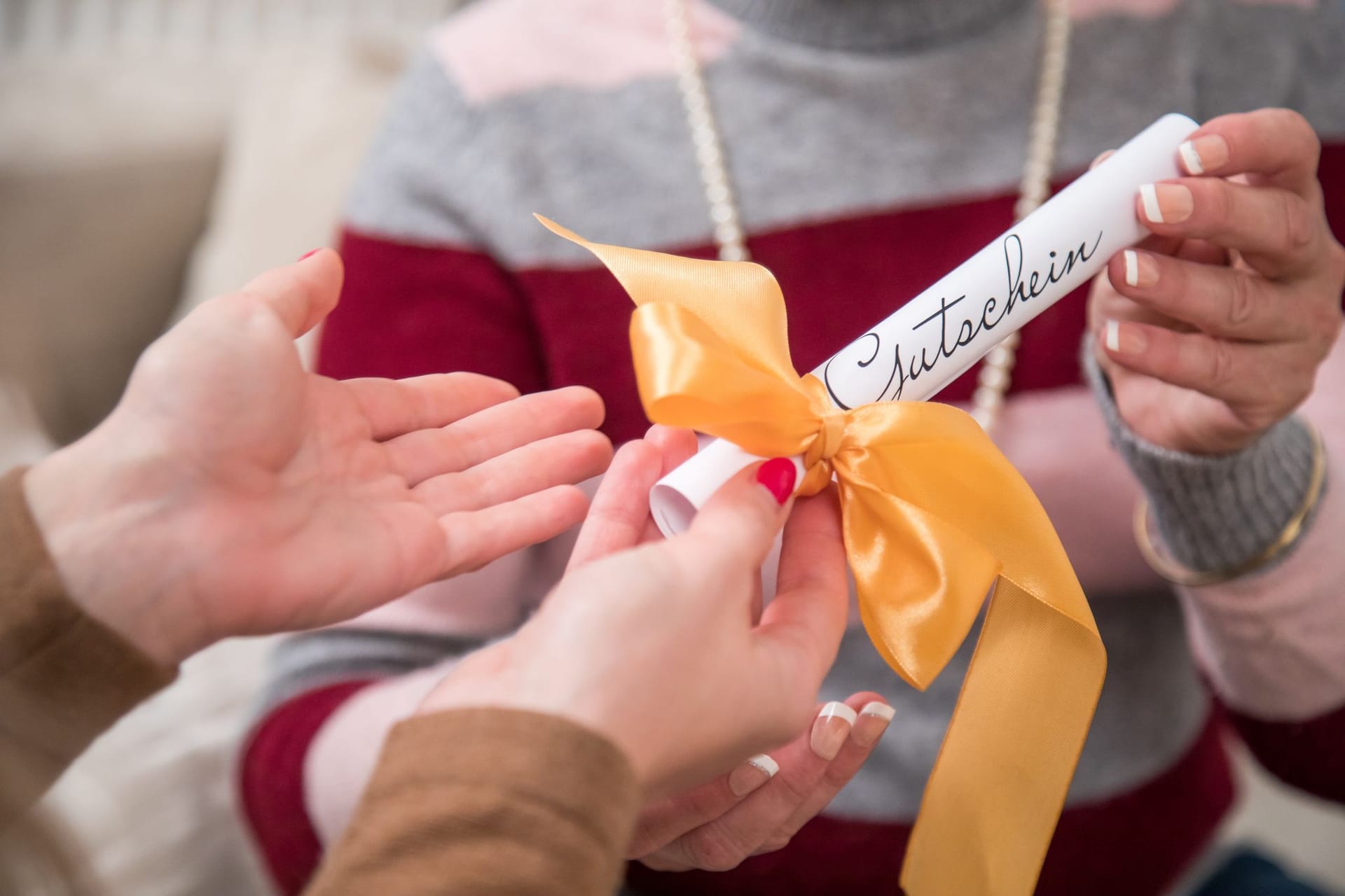 Eine Frau überreicht einen Geschenkgutschein