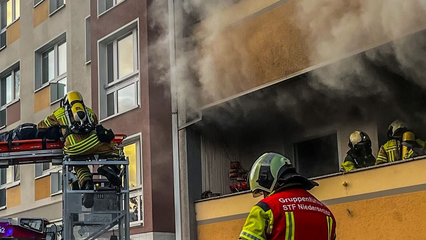 Wohnungsbrand in Dresden: Einsatzkräfte der Feuerwehr retten über eine Drehleiter eine schwer verletzte Person.