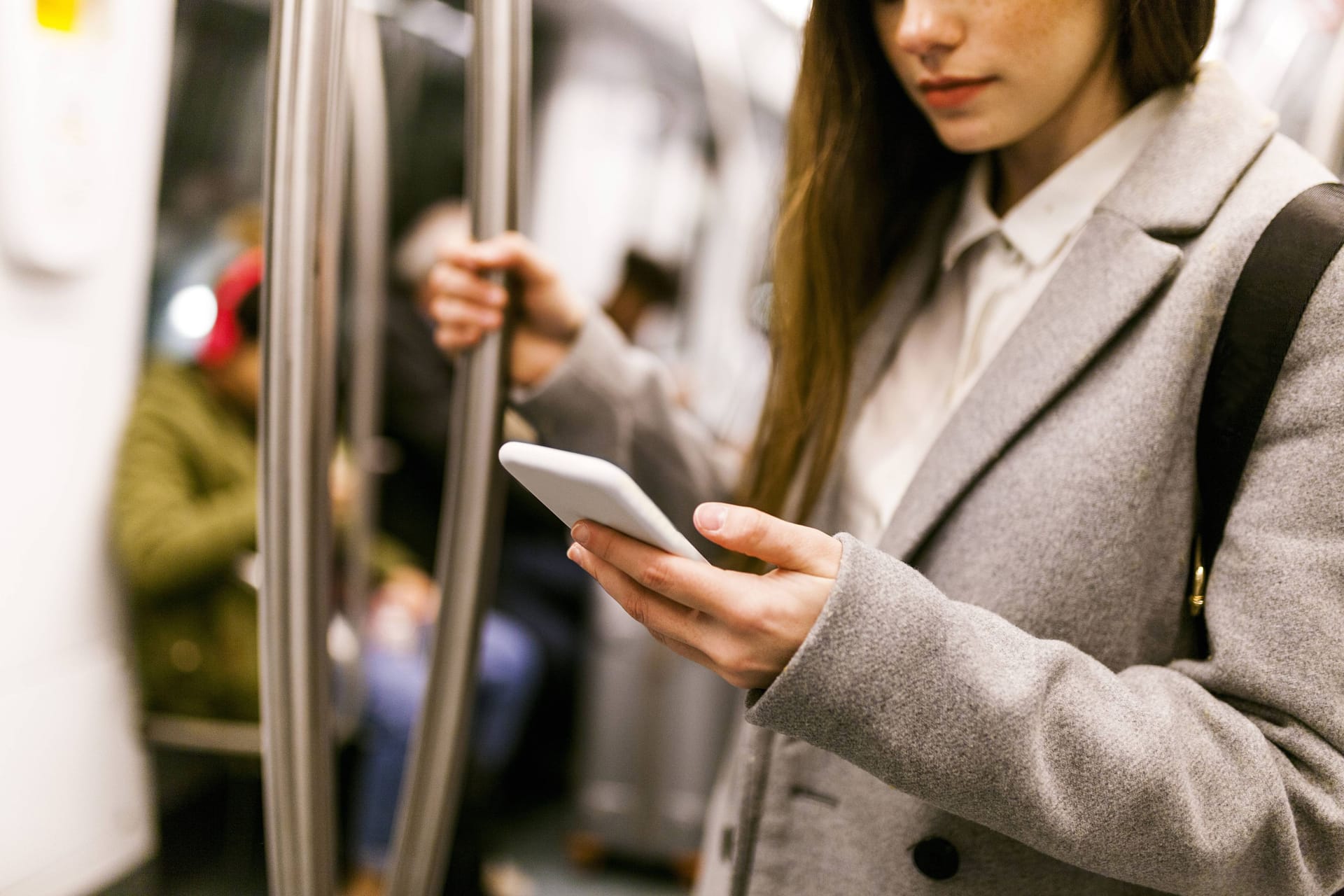 Eine Frau schaut in der U-Bahn auf ihr Smartphone (Archivbild): In Berlin laufen bereits entsprechenden Ansagen in den öffentlichen Verkehrsmitteln.