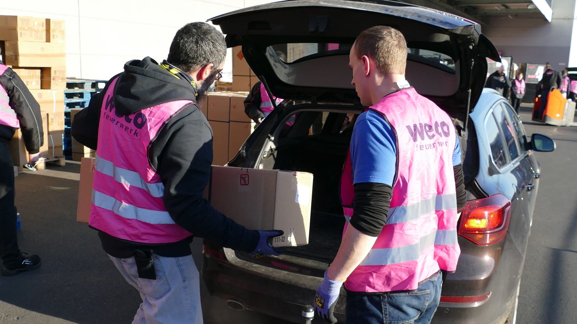 Weco-Mitarbeiter laden die Überraschungspakete mit Feuerwerk in die Autos.