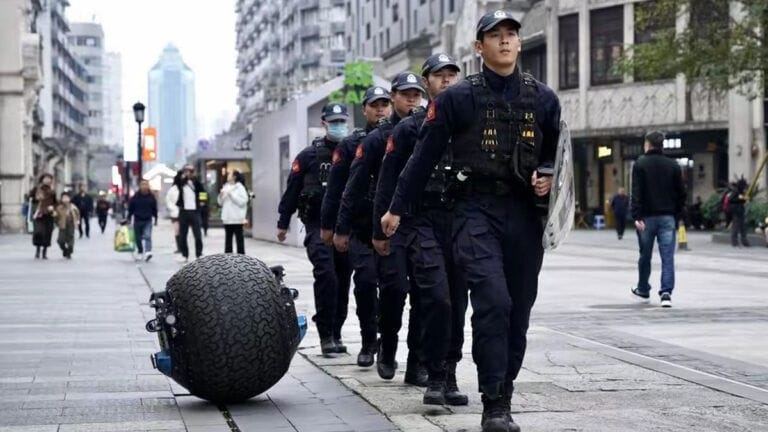 Chinesische Polizisten gehen in Wenzhou mit einem Kugelroboter auf Streife.