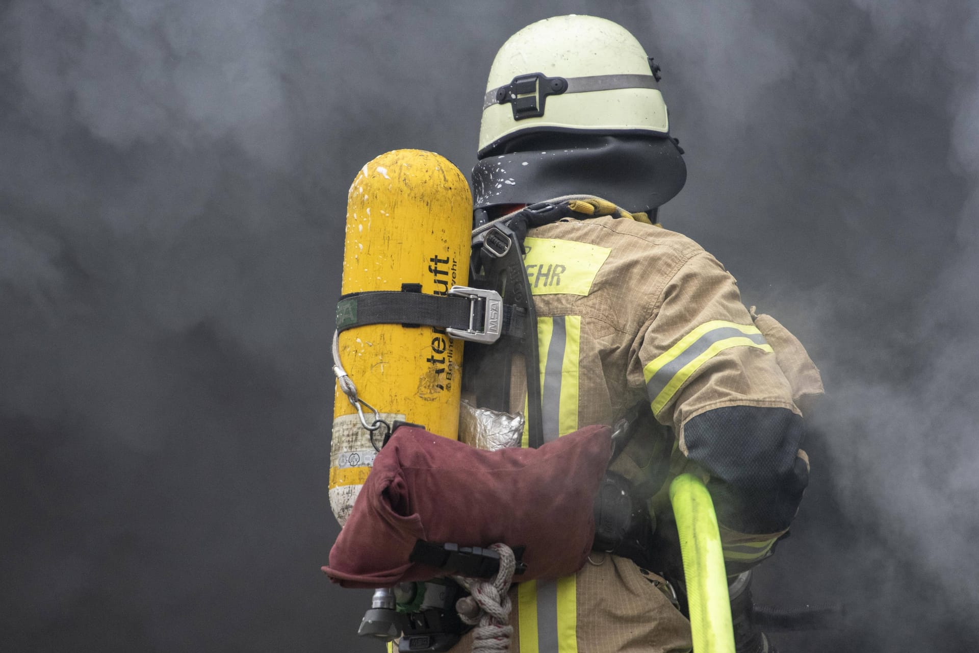 Eine Rettungskraft löscht ein Feuer (Symbolbild): In Braunschweig ist ein Mann bei einem Wohnungsbrand getötet worden.