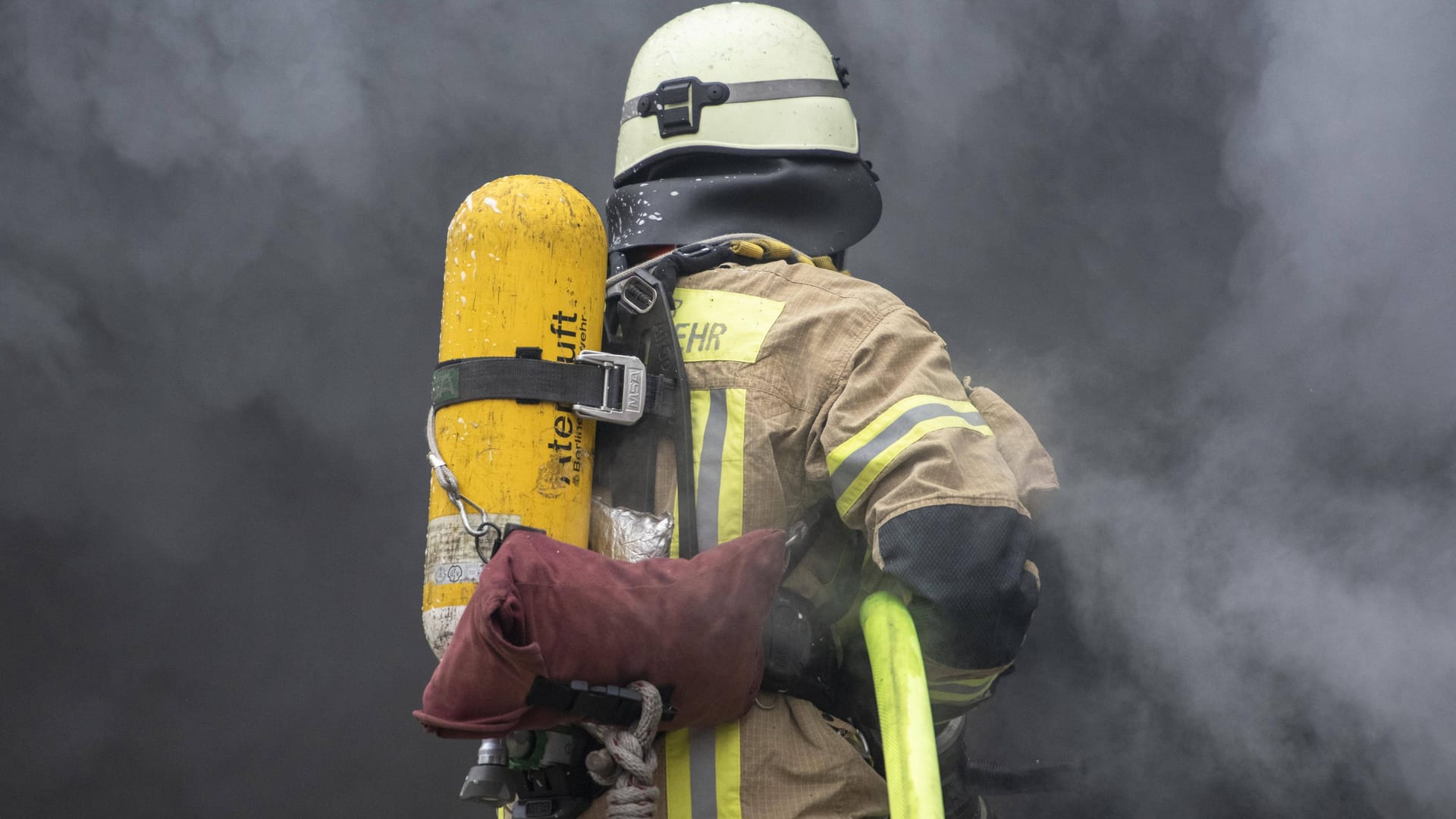 Eine Rettungskraft löscht ein Feuer (Symbolbild): In Braunschweig ist ein Mann bei einem Wohnungsbrand getötet worden.