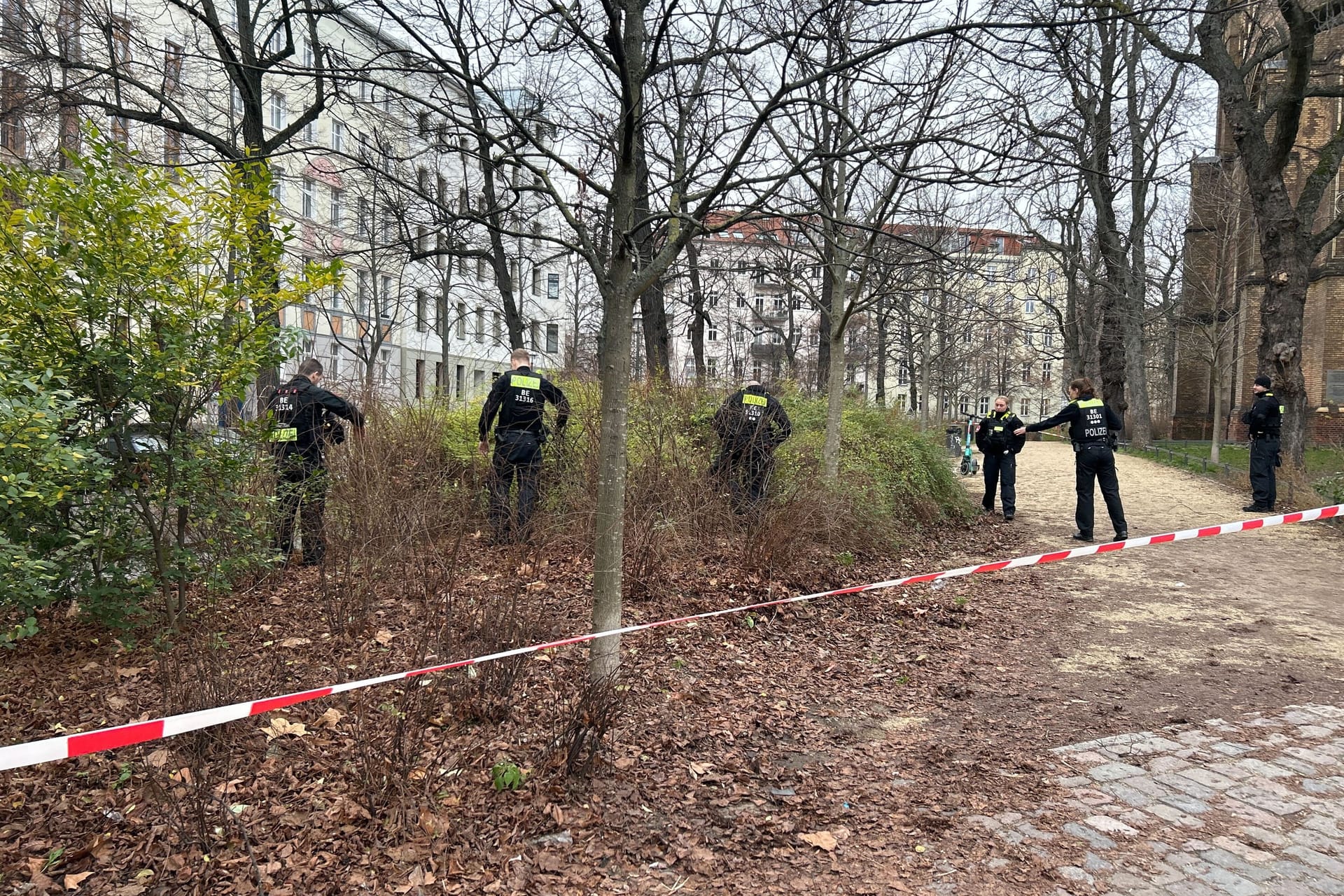 Polizisten suchen ein Waldstück ab: Offenbar sind sie auf der Suche nach weiteren Pfeilen.