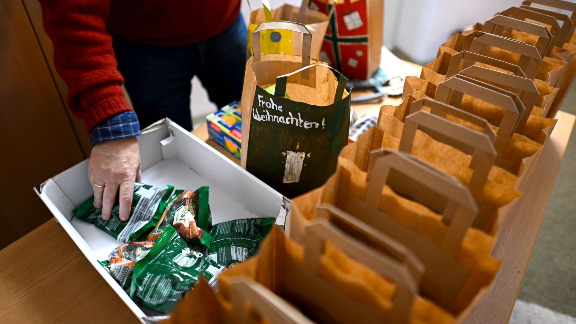 PRODUKTION - 16.12.2024, Bremen: Pastor Christian Fischer bereitet Weihnachtstüten vor, die an die Insassen der Justizvollzugsanstalt Bremen verteilt werden. Die Gefangenen bekommen vor Weihnachten eine Tüte mit Süßigkeiten, Kaffee und einem kleinen Jahreskalender. Die Weihnachtsaktion gibt es seit rund 20 Jahren.