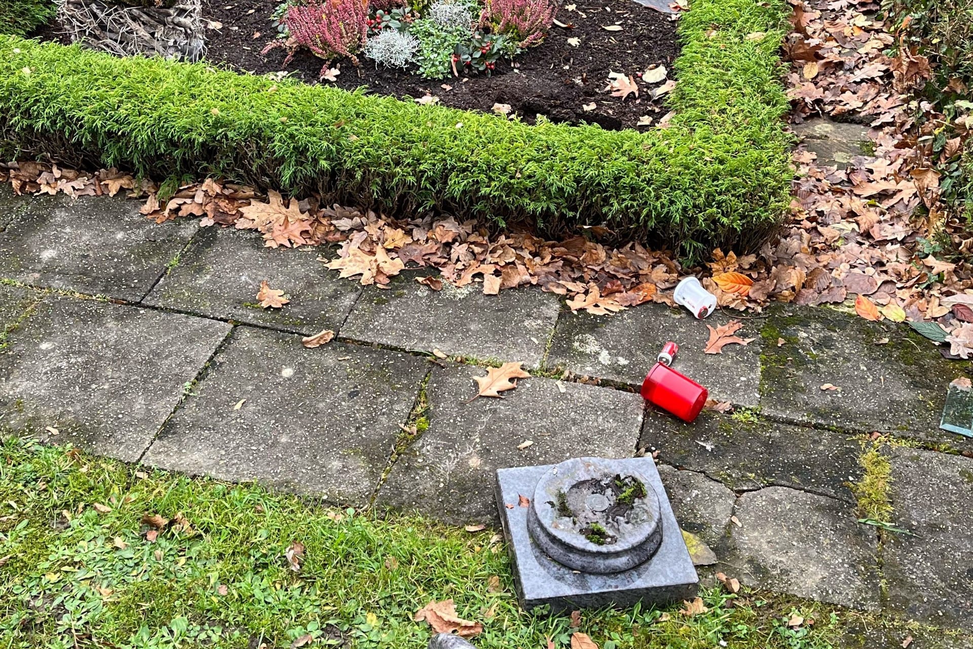 Eine völlig zerstörte Grableuchte liegt auf dem Boden des Eschweiler Friedhofs. Vandalen haben hier erheblichen Schaden angerichtet.