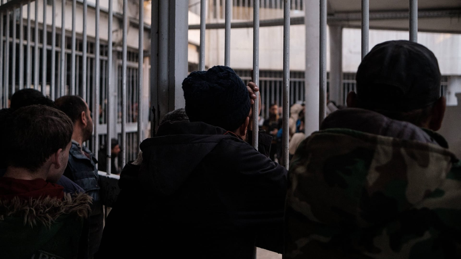 Menschen halten nach ihren inhaftierten Angehörigen Ausschau, nach dem Rebellen ein Gefängnis befreit haben.