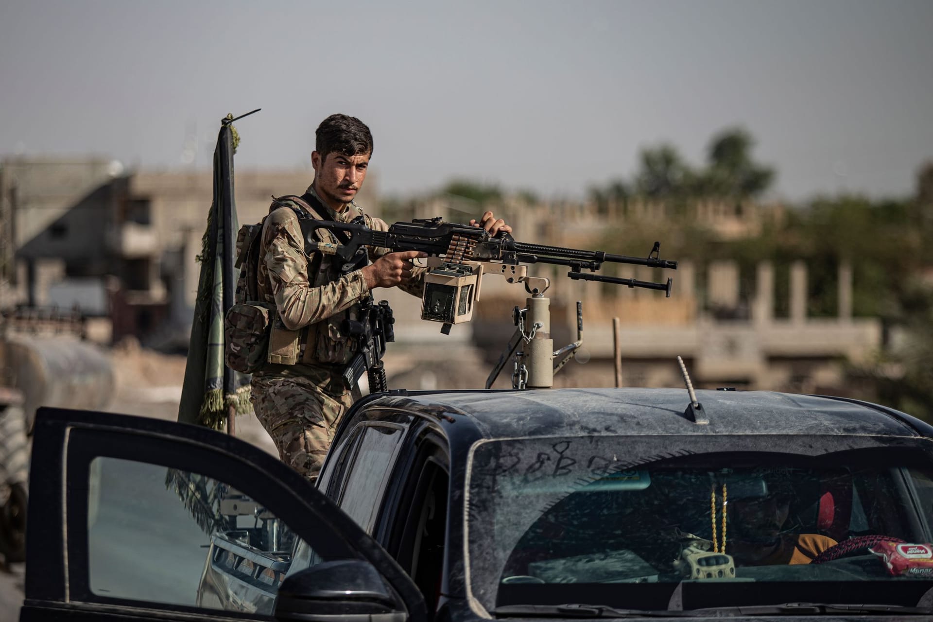 Ein von den USA unterstützter Kämpfer der Syrischen Demokratischen Kräfte (SDF) steht auf einem gepanzerten Fahrzeug in Ostsyrien.