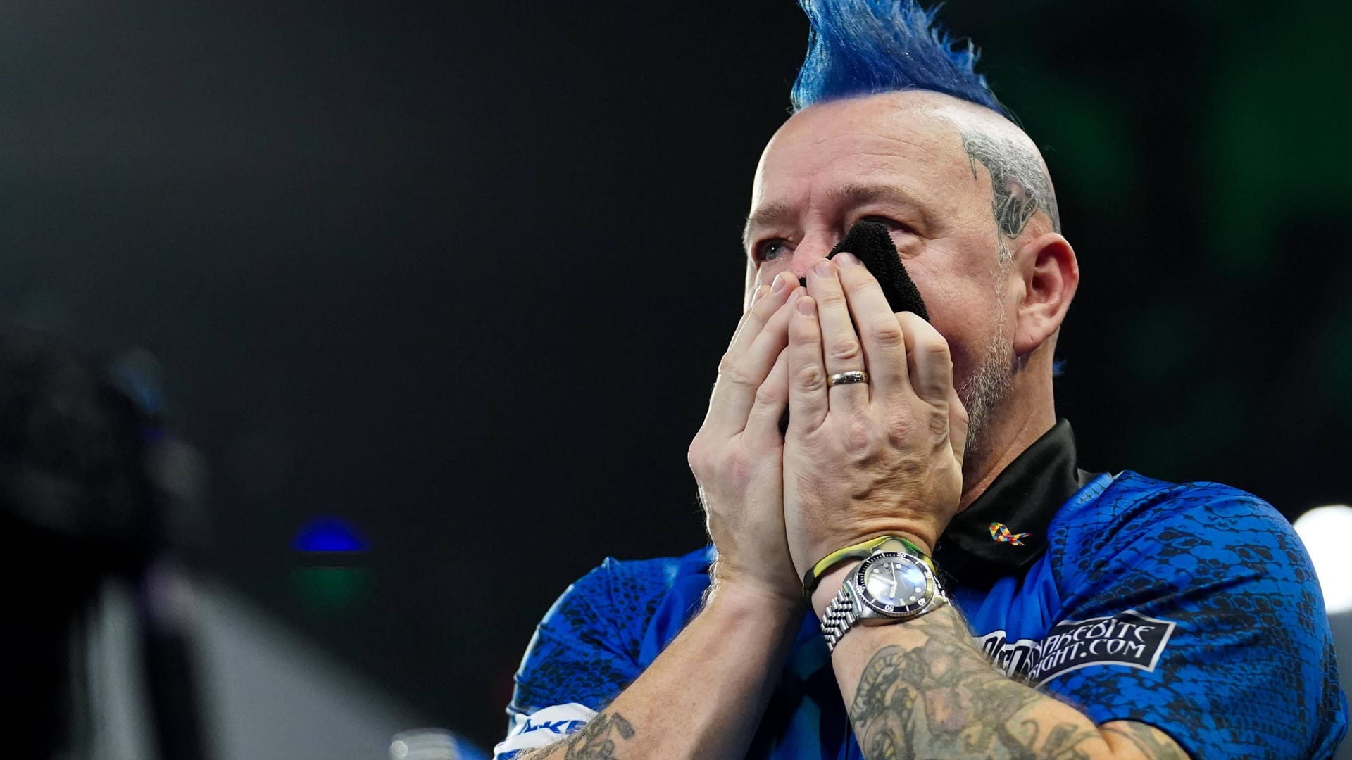 Peter Wright drückt sich ein Handtuch vor den Mund: Der Ex-Weltmeister ist nicht fit.