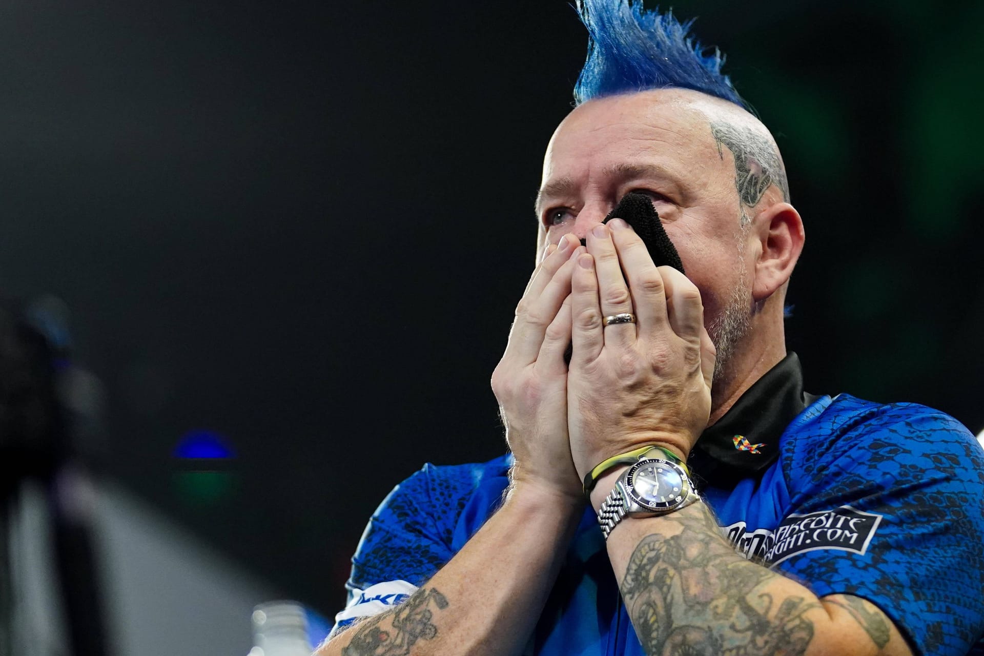 Peter Wright drückt sich ein Handtuch vor den Mund: Der Ex-Weltmeister ist nicht fit.