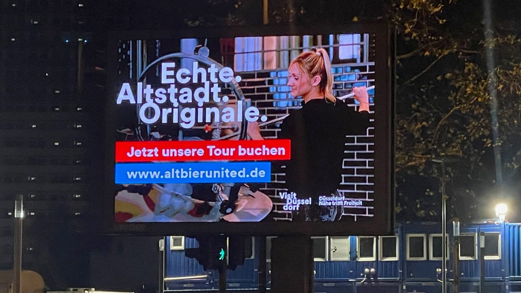 Auf einem Screen in Köln läuft gerade die Werbung aus Düsseldorf.