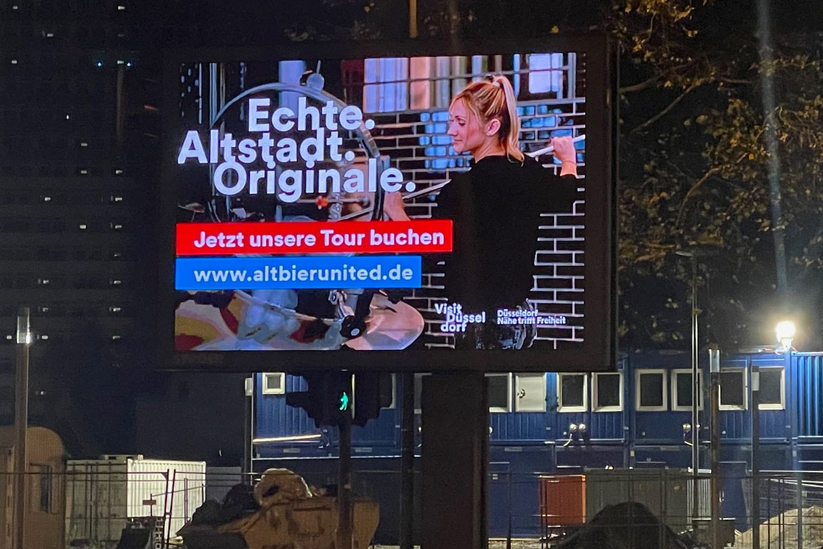 Auf einem Screen in Köln läuft gerade die Werbung aus Düsseldorf.