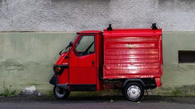 Eine rote Piaggio "Ape" steht vor einem Haus. (Archivbild)