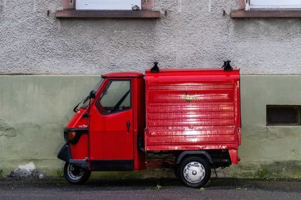 Eine rote Piaggio "Ape" steht vor einem Haus. (Archivbild)