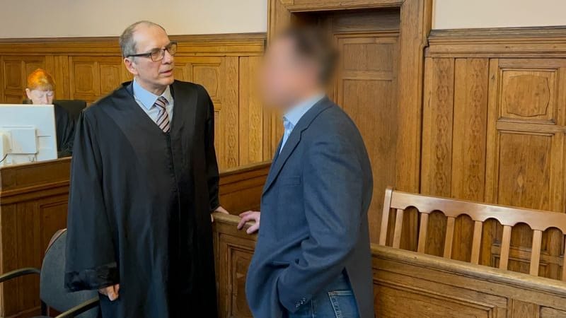 Prozess um Flagge: Der angeklagte Lehrer (r.) steht mit seinem Anwalt Uwe Freyschmidt im Gerichtssaal.