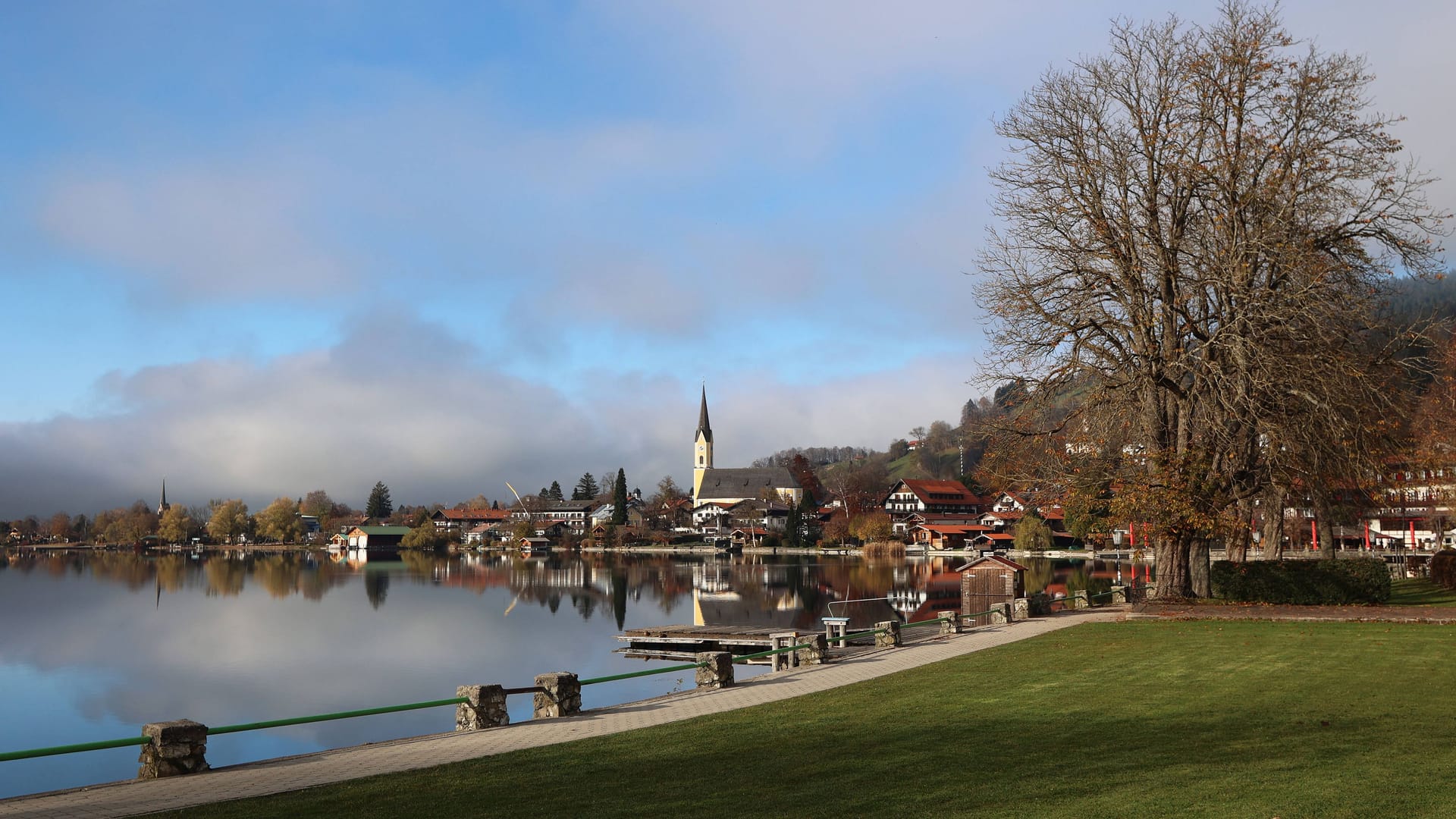 Nebel löst sich über dem Schliersee auf: Im Hintergrund ist die Kirche St. Sixtus zu sehen.